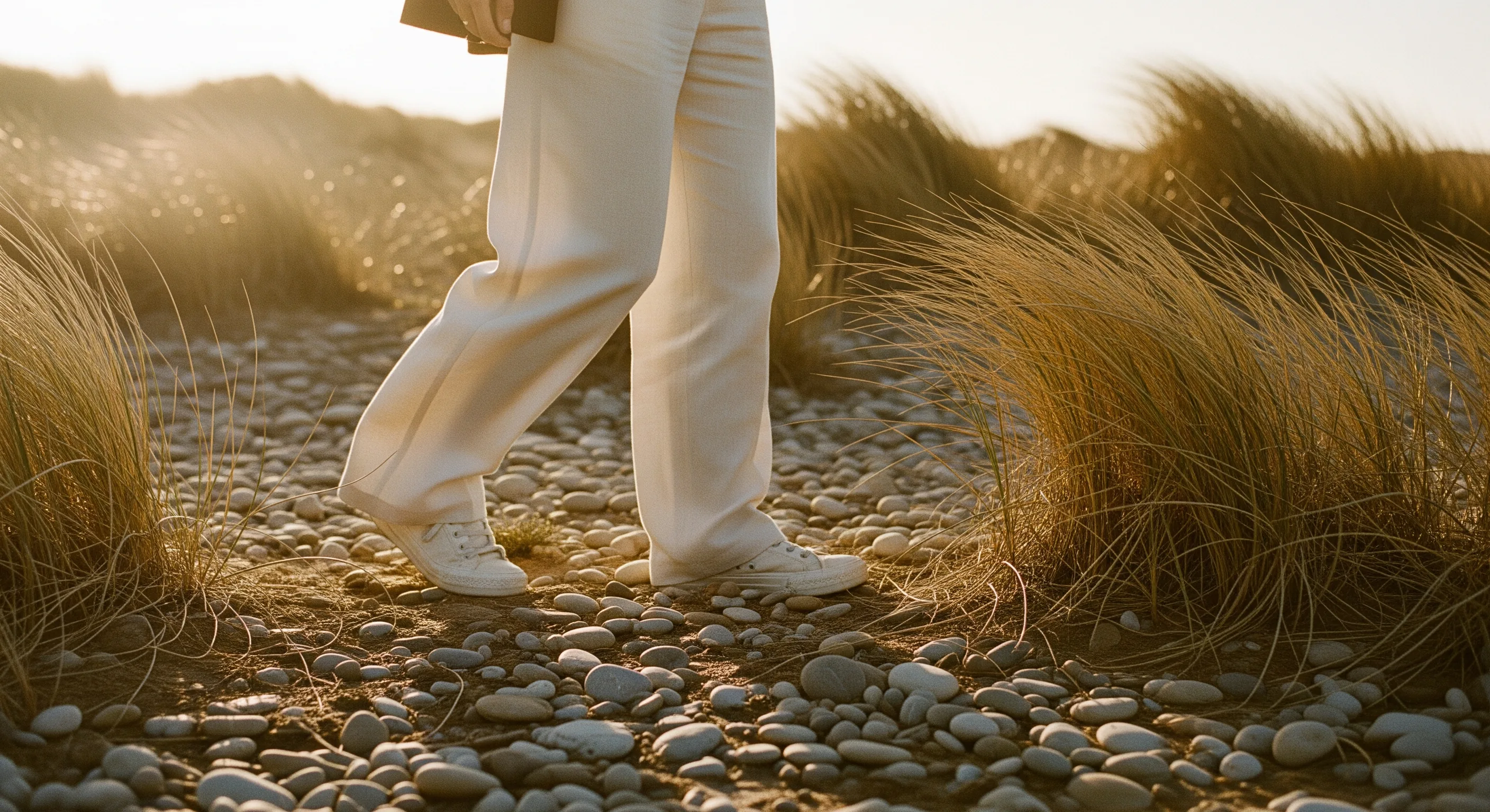 Worn canvas sneakers resting on warm sandy ground